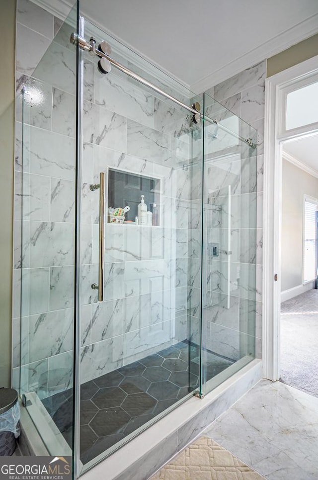 bathroom featuring ornamental molding and a shower with shower door