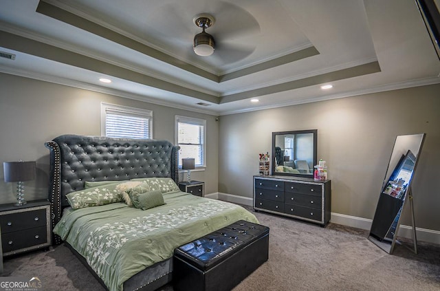 carpeted bedroom with ornamental molding and a raised ceiling