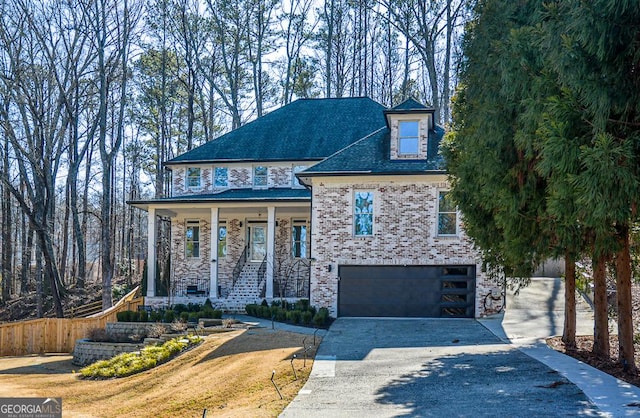 view of front of house with a garage, a front yard, and covered porch