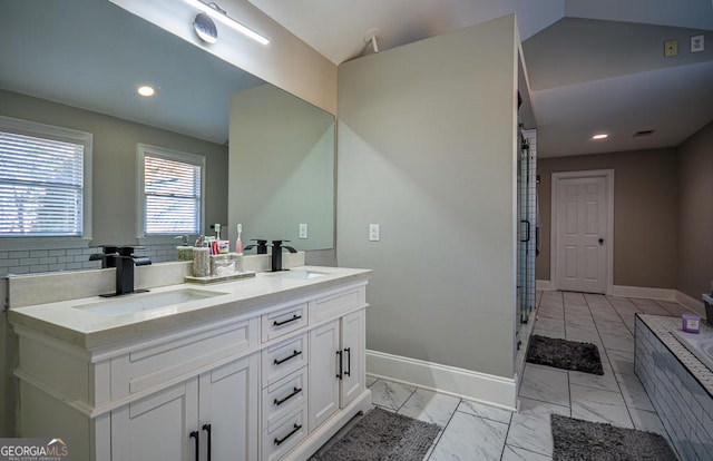 bathroom with vanity, decorative backsplash, and lofted ceiling