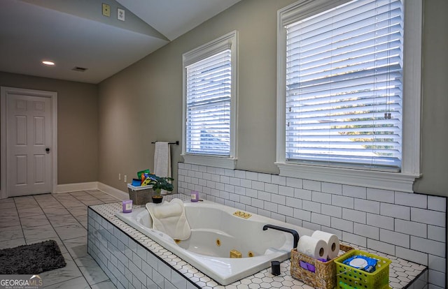 bathroom with a relaxing tiled tub