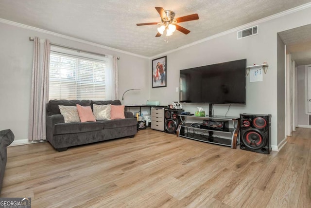 living room with crown molding, a textured ceiling, and light wood-type flooring