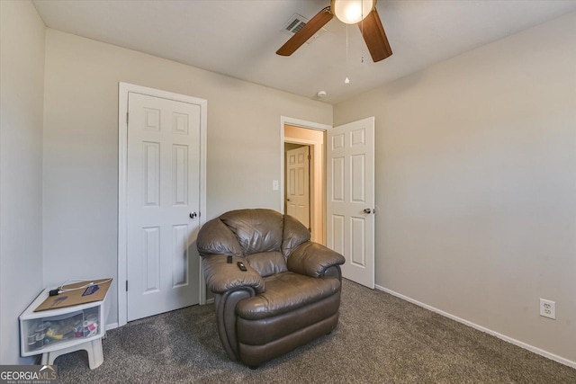 sitting room featuring ceiling fan and dark carpet