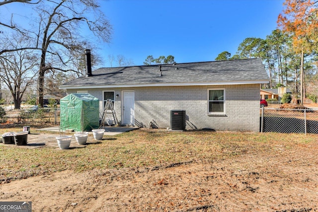 rear view of property with a yard and central air condition unit