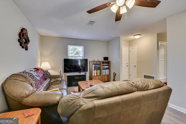 living room with light hardwood / wood-style floors and ceiling fan