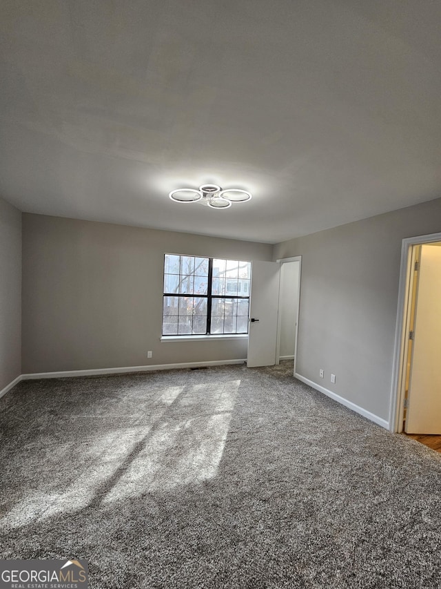 empty room featuring baseboards and carpet floors