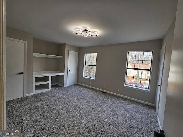 unfurnished bedroom with dark colored carpet