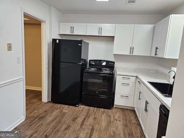 kitchen featuring white cabinetry, sink, light hardwood / wood-style flooring, and black appliances