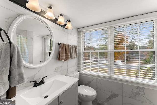 bathroom with vanity, tile walls, toilet, and a shower with shower curtain