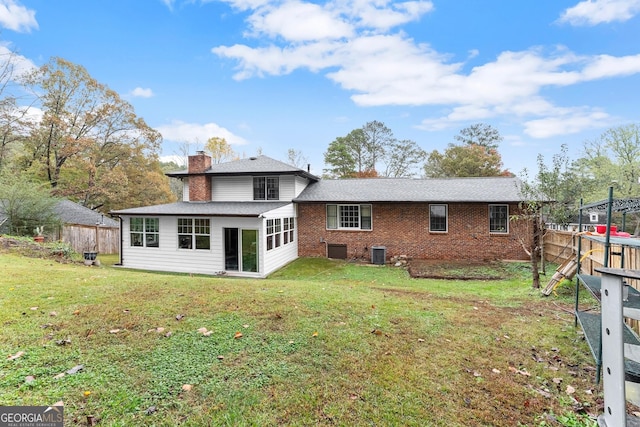 back of house featuring a yard and central AC unit