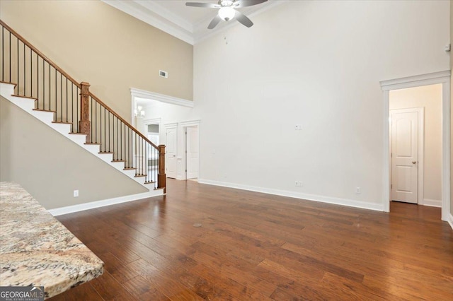 living room with ornamental molding, dark hardwood / wood-style floors, ceiling fan, and a high ceiling