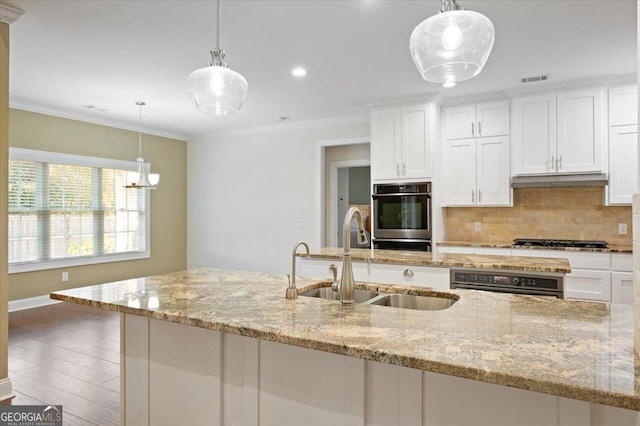 kitchen featuring white cabinetry, sink, and decorative light fixtures