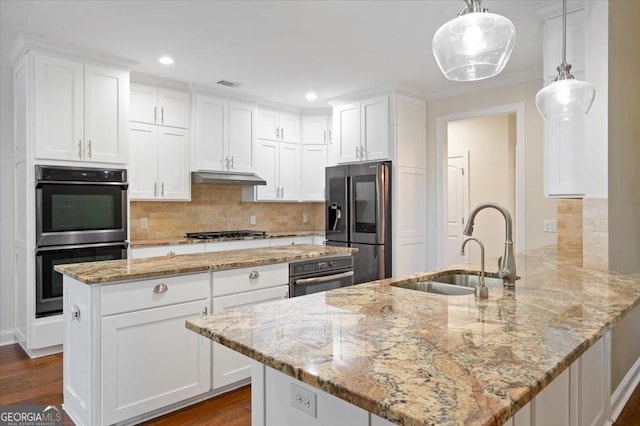 kitchen with pendant lighting, sink, appliances with stainless steel finishes, white cabinetry, and kitchen peninsula