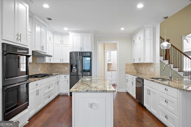 kitchen with appliances with stainless steel finishes, sink, white cabinets, hanging light fixtures, and light stone countertops