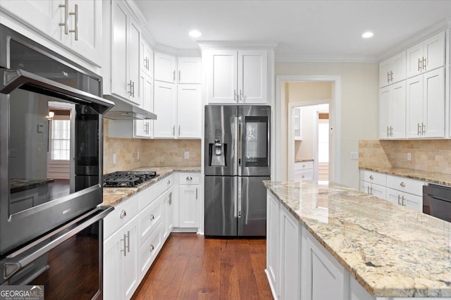 kitchen with light stone counters, appliances with stainless steel finishes, and white cabinets