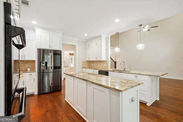 kitchen with pendant lighting, sink, stainless steel refrigerator with ice dispenser, white cabinets, and a kitchen island