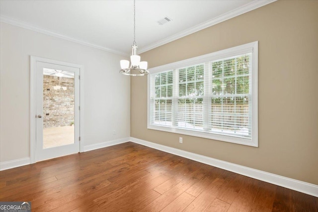 unfurnished dining area with a notable chandelier, crown molding, and dark hardwood / wood-style floors