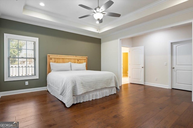 bedroom featuring crown molding, dark hardwood / wood-style floors, a raised ceiling, and ceiling fan