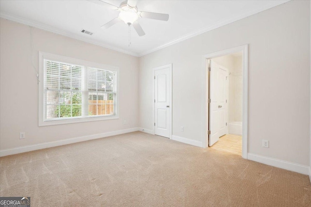 unfurnished bedroom with crown molding, light colored carpet, ceiling fan, and ensuite bathroom