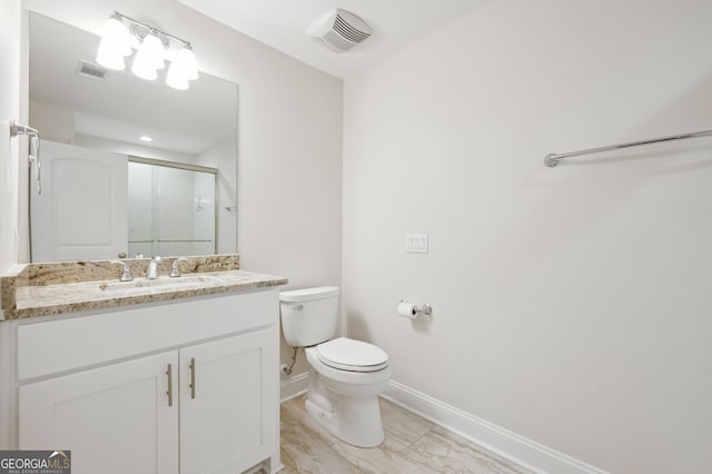 bathroom featuring vanity, a shower with door, and toilet