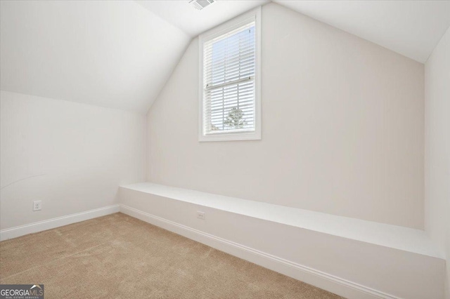 bonus room featuring light carpet and vaulted ceiling