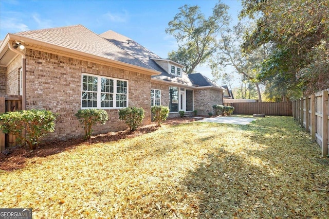 back of property with a yard and a patio