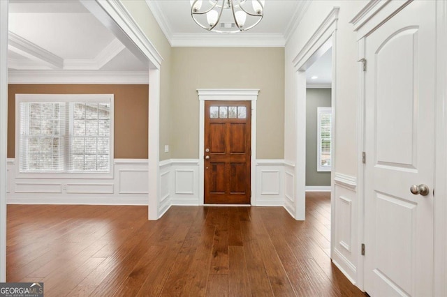 entryway featuring an inviting chandelier, ornamental molding, and dark wood-type flooring