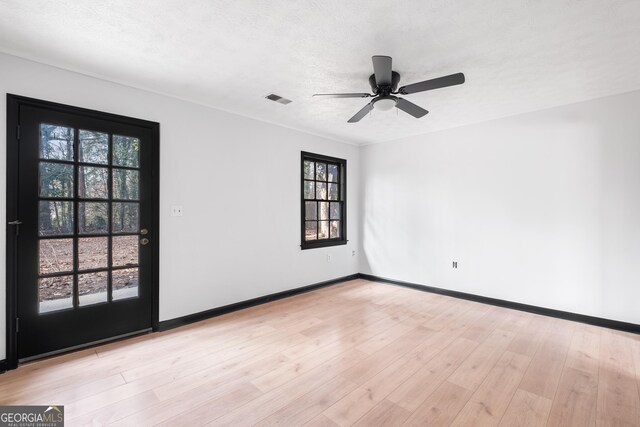 spare room featuring ceiling fan, light hardwood / wood-style floors, and a textured ceiling