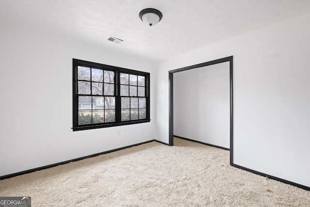 unfurnished bedroom with light carpet, a closet, and a textured ceiling