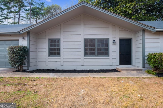 ranch-style house with a garage and a front lawn