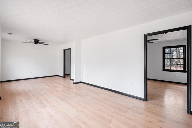 empty room with ceiling fan, light hardwood / wood-style floors, and a textured ceiling