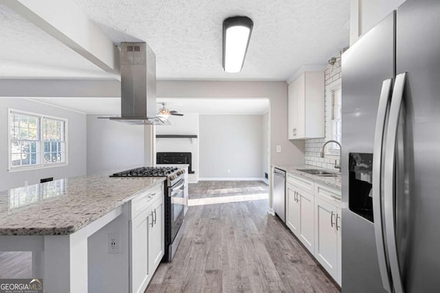 kitchen with sink, stainless steel appliances, white cabinets, and island exhaust hood