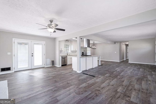 unfurnished living room featuring sink, dark hardwood / wood-style floors, a textured ceiling, ceiling fan with notable chandelier, and french doors