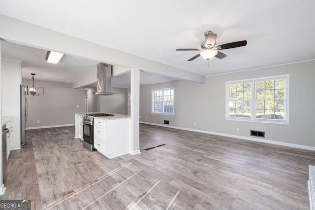 kitchen featuring appliances with stainless steel finishes, pendant lighting, island range hood, white cabinets, and light hardwood / wood-style flooring