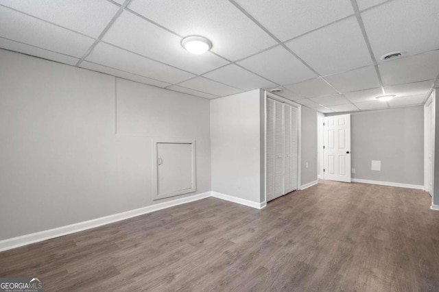 basement with a drop ceiling and hardwood / wood-style flooring