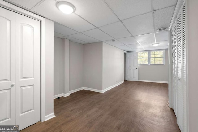 basement with dark wood-type flooring and a drop ceiling