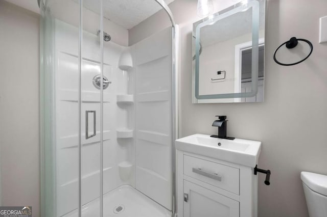 bathroom with vanity, toilet, and a shower with shower door