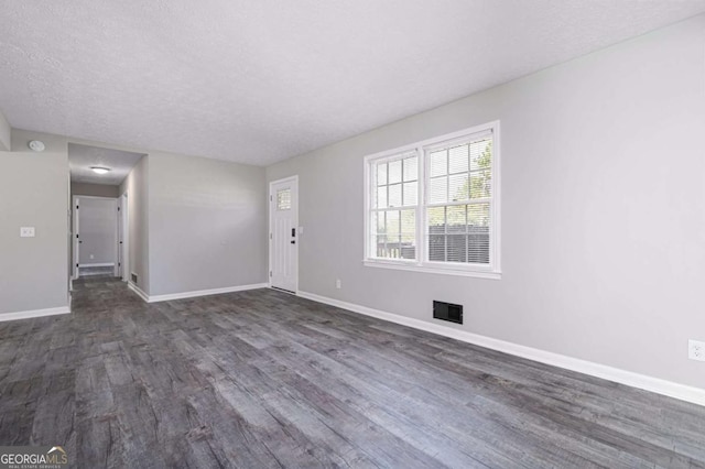 unfurnished room with dark hardwood / wood-style floors and a textured ceiling