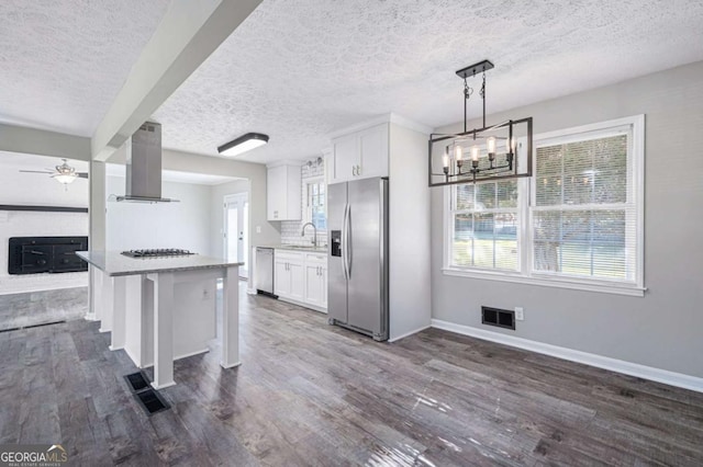 kitchen featuring appliances with stainless steel finishes, sink, island range hood, and white cabinets