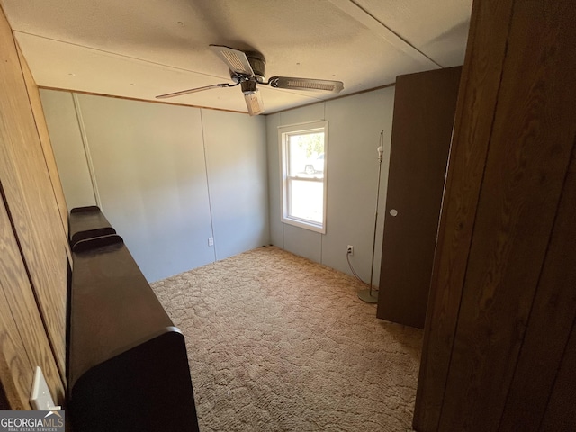 empty room with ceiling fan and carpet flooring