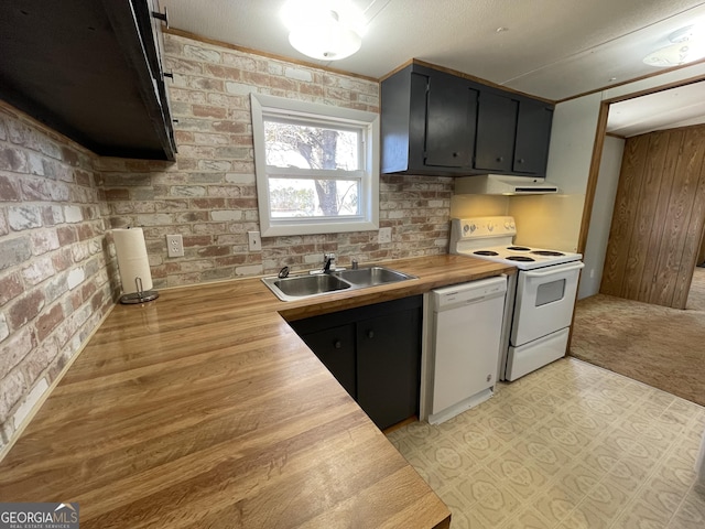 kitchen with wood counters, sink, white appliances, and brick wall