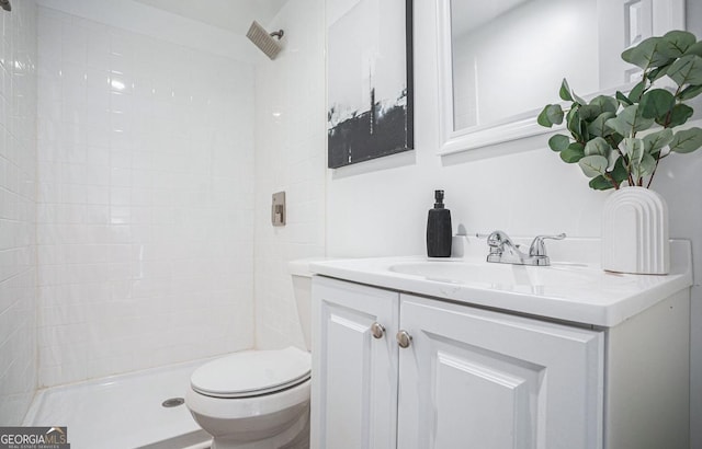 bathroom featuring vanity, toilet, and tiled shower