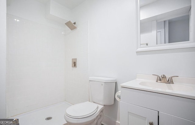 bathroom featuring tiled shower, vanity, and toilet