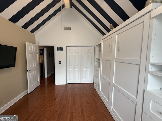 unfurnished bedroom with dark hardwood / wood-style floors and high vaulted ceiling