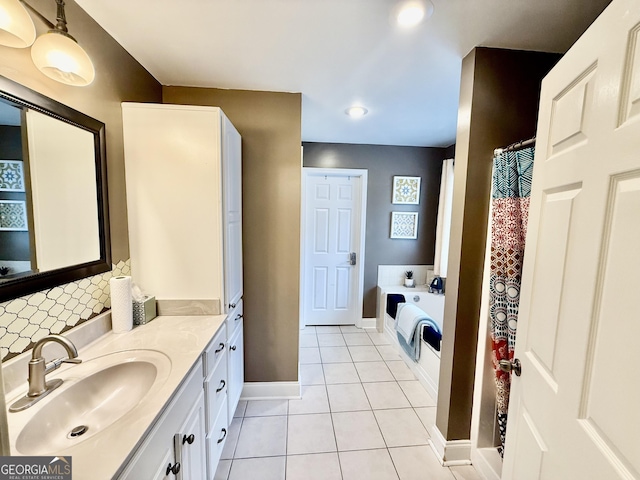 full bathroom with tile patterned flooring, baseboards, decorative backsplash, a bath, and vanity