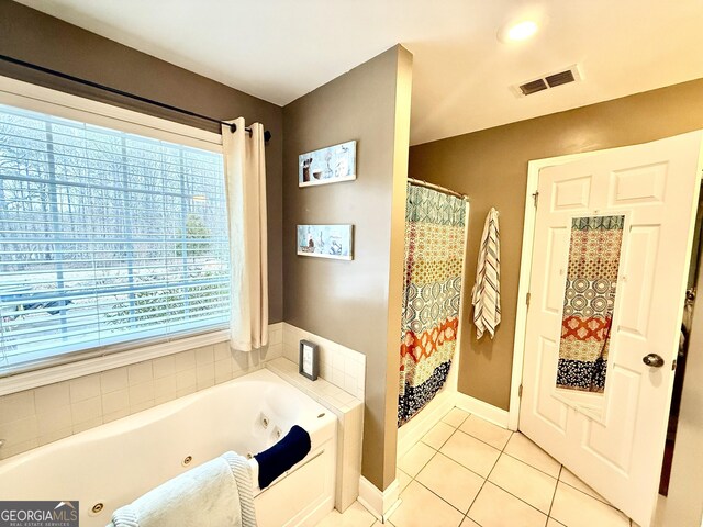 bathroom with tile patterned flooring, visible vents, baseboards, and a tub with jets