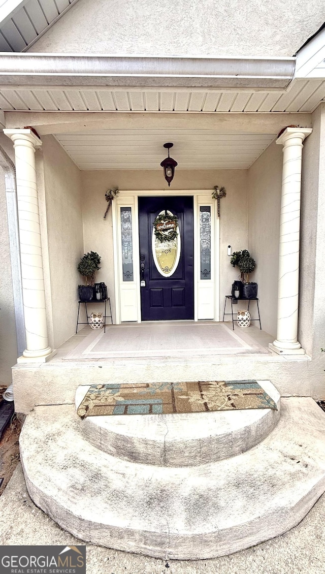 view of exterior entry featuring stucco siding