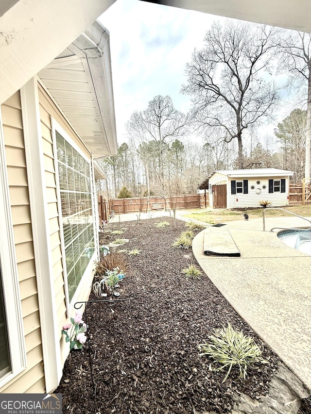 view of yard featuring an exterior structure, a patio, an outbuilding, and a fenced backyard