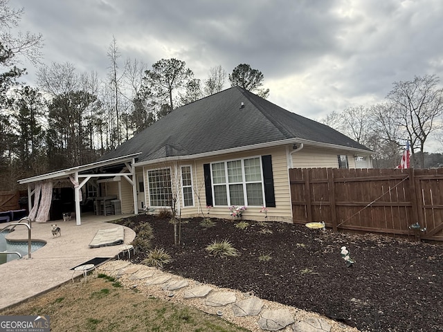 back of house featuring a fenced in pool and a patio