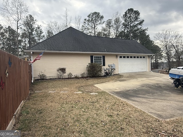 view of side of property with a garage and a lawn